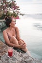 Vertical of a Caucasian beautiful woman relaxing in a resort pool with a fresh detox juice cocktail Royalty Free Stock Photo