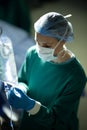 Vertical of caucasian female surgical tech preparing iv bag in operating theatre during opertion