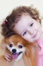 Child hugs his dog with love. childhood friends. happy girl and pomeranian