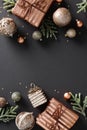 Vertical Christmas banner with elegant bronze baubles, gift boxes and festive confetti on a grey background. Copy space for