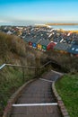 Vertical cityscape of Helgoland, Germany, taken from the cliff above the city. Staircase going down in the front, on a