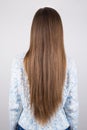 Vertical close up back behind rear view photo of woman demonstrating showing her long but problematic hair isolated grey