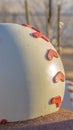 Vertical Close up of huge red and white baseball decoration at a park