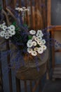 Vertical close up macro shot of fake plastic white daisy and blue purple lavender flowers arrangement in a sack basket pot hanging Royalty Free Stock Photo