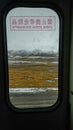 VERTICAL: Oval shaped train window offers a stunning view of the snowy Himalaya.