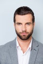 Vertical close up portrait of serious young minded man in white