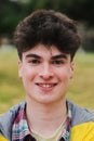 Vertical close up portrait of teenage male student smiling and looking at camera in a college. Front view of caucasian Royalty Free Stock Photo