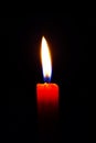 Vertical close up a single red wax candle light up blue fire middle position total dark black isolated background meditation macro