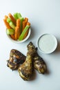 Vertical close up top view shot of isolated grilled barbecue chicken wings, legs, a bowl of fresh orange carrots and juicy green Royalty Free Stock Photo