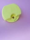 Vertical close up of yellow-green box,holder,for orthodontic device for lip bumpers,aligner,dental plate,pink backdrop