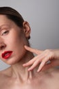 Vertical close-up of young woman with perfect skin and red lips posing indoor. Royalty Free Stock Photo