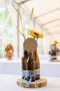 Vertical closeup of beer bottles with wheat and a sunflower on the table. Oktoberfest, Germany.