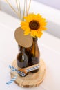 Vertical closeup of beer bottles with wheat and a sunflower on the table. Oktoberfest, Germany.