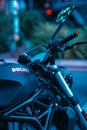 Vertical closeup of a black Ducati motorcycle in the downtown area.