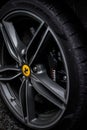 Vertical closeup of a black Ferrari wheel in Hale Village, United Kingdom