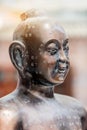Vertical closeup of a bronze acupuncture buddhist sculpture with Chinese engravings Royalty Free Stock Photo