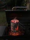 Vertical closeup of burning charcoal with flames in a chimney starter Royalty Free Stock Photo