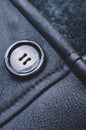 Vertical closeup of the button on a beautifully textured, navy blue leather jacket Royalty Free Stock Photo