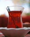 Vertical closeup of a cup of Turkish tea with a spoon in it Royalty Free Stock Photo