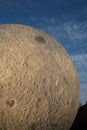 Vertical closeup of a giant model of the Moon against a blue sky in Brno Observatory and Planetarium