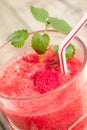 Vertical closeup of a glass of raspberry smoothie, with a plastic straw Royalty Free Stock Photo