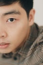 Vertical closeup half face portrait of an Asian handsome man with a serious facial expression Royalty Free Stock Photo