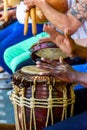 Vertical closeup of the hands playing atabaque, a tall, wooden, Afro-Brazilian hand drum.