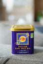 Vertical closeup of a Lipton brand Russian Earl Grey tea in a metal box isolated on a couch