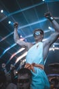 Vertical closeup of a male, shield sunglasses, sitting on somebody's shoulders, enjoying concert