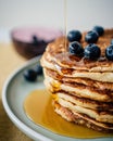 Vertical closeup of maple syrup being poured on buttermilk pancakes stack with blueberries Royalty Free Stock Photo