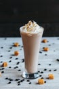 Vertical closeup of a milkshake on the white towel covered with sweets, dark blurred background