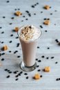 Vertical closeup of a milkshake on the white towel covered with sweets, dark blurred background