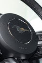 Vertical closeup of Mustang steering wheel badge, horse running logo, muscle car