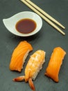 Vertical closeup of Nigirizushi sushi with shrimp and salmon served with soy sauce and chopsticks Royalty Free Stock Photo