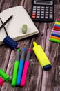 Vertical closeup of an open notebook with a black pencil, eraser, colored markers, and a calculator Royalty Free Stock Photo