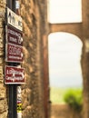 Vertical closeup of a post sign with directions to different locations captured in a street in Italy