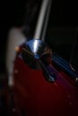 Vertical closeup of a red vintage car's side mirror detail Royalty Free Stock Photo