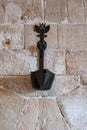 Vertical closeup shot of an ancient oil lamp hanging on the rock wall of Bellver castle in Palma