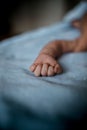 Vertical closeup shot of a baby hand laying on the bed. Cute baby fingers, perfect for wallpaper Royalty Free Stock Photo