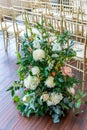 Vertical closeup shot of a beautiful floral composition next to the chairs in the wedding venue Royalty Free Stock Photo