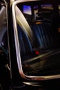Vertical closeup shot of a black luxurious shiny vehicle parked on the street during nighttime Royalty Free Stock Photo