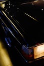 Vertical closeup shot of a black luxurious shiny vehicle parked on the street during nighttime Royalty Free Stock Photo