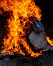 Vertical closeup shot of a campfire with flames and smoke at campsite at night Royalty Free Stock Photo