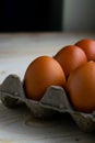 Vertical closeup shot of chicken eggs in a carton box on a table Royalty Free Stock Photo