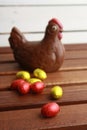 Vertical closeup shot of chocolate hen and candy Easter eggs on a wooden table Royalty Free Stock Photo