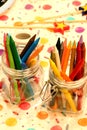 Vertical closeup shot of colorful crayons in glass jars Royalty Free Stock Photo