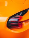 Vertical closeup shot of the cool design of a backlight on an orange sports car Royalty Free Stock Photo