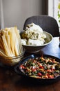 Vertical closeup shot of corn masa, corn husk, and roasted vegetables for making tamales