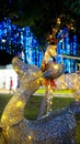 Vertical closeup shot of a cute glowing yellow reindeer in a park during Christmas at night