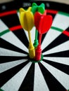 Vertical closeup shot of a dartboard with three darts on the bullseye Royalty Free Stock Photo